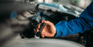 technician checks brake fluid level in car. Auto-service, vehicle maintenance, repairman with tools