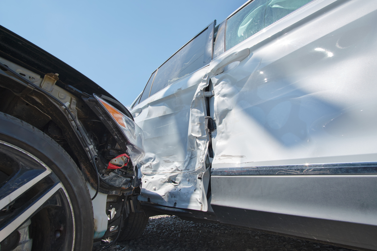 Cars crashed heavily in t-bone road accident after collision on city street.