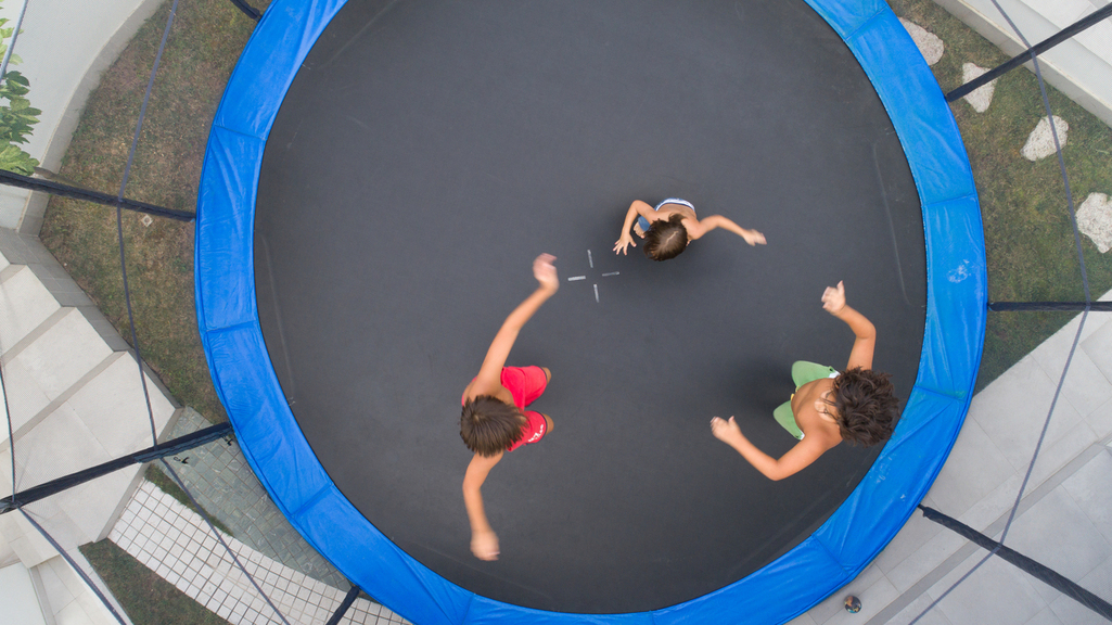 Children playing on trampoline aerial view together