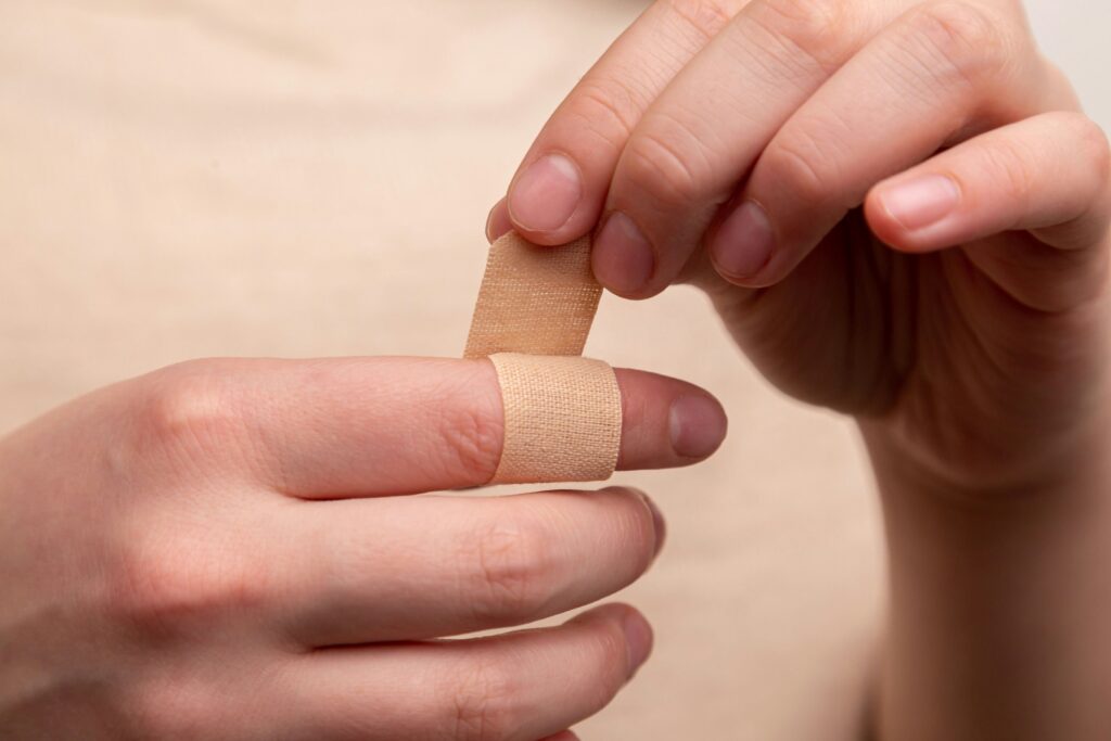 Someone putting a band aid on their finger